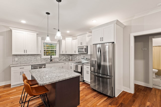 kitchen featuring white cabinetry, a center island, light hardwood / wood-style floors, and appliances with stainless steel finishes