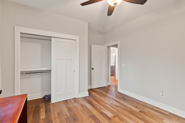 unfurnished bedroom with ceiling fan, a closet, and wood-type flooring