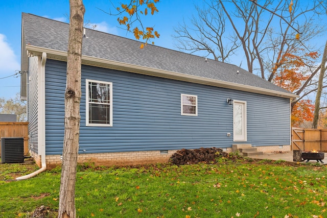 back of house featuring a lawn and central air condition unit