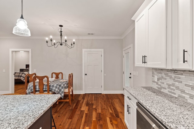 kitchen featuring light stone countertops, white cabinetry, and pendant lighting