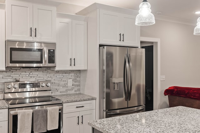 kitchen featuring hanging light fixtures, tasteful backsplash, appliances with stainless steel finishes, white cabinets, and ornamental molding