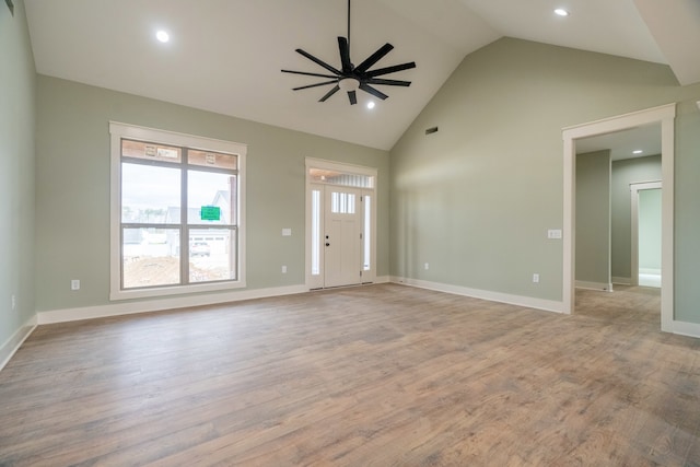 unfurnished living room featuring ceiling fan, high vaulted ceiling, and light hardwood / wood-style flooring