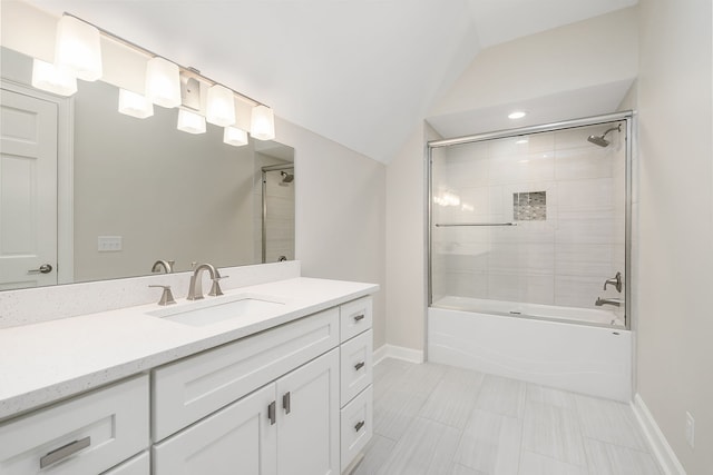 bathroom with vanity, tiled shower / bath combo, and vaulted ceiling