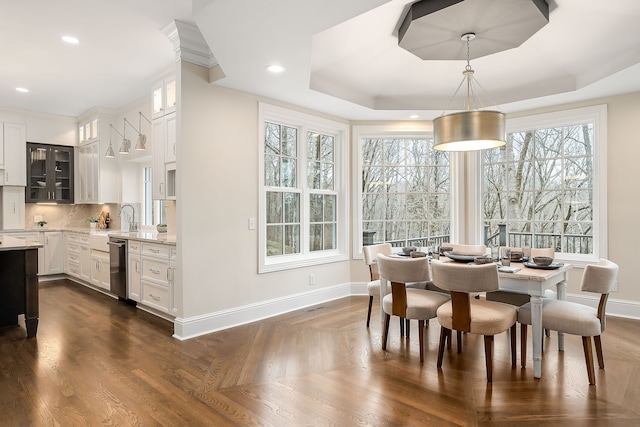 dining space with a raised ceiling and sink