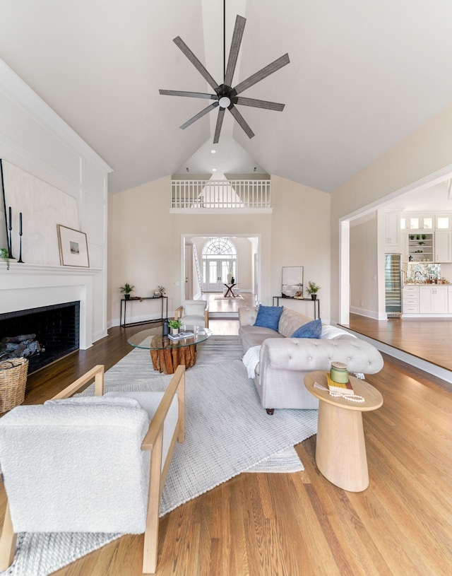 living room featuring a fireplace, hardwood / wood-style flooring, ceiling fan, and lofted ceiling