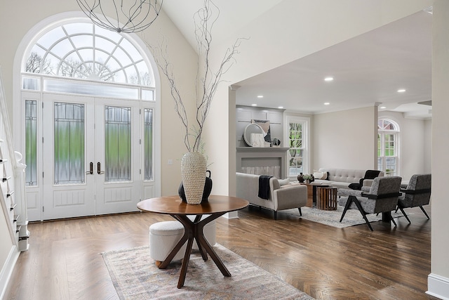 foyer entrance featuring wood-type flooring, a towering ceiling, and french doors