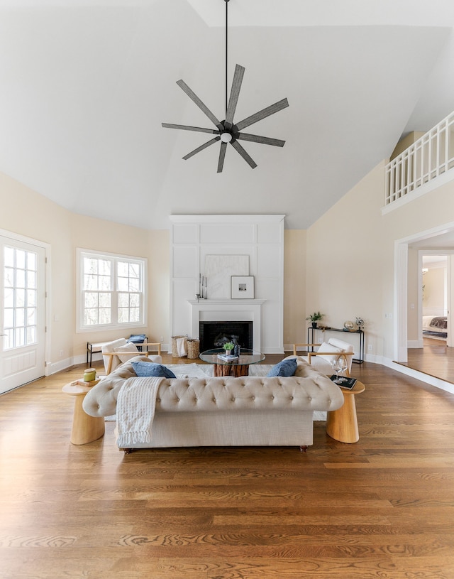 living room featuring wood-type flooring, high vaulted ceiling, and ceiling fan