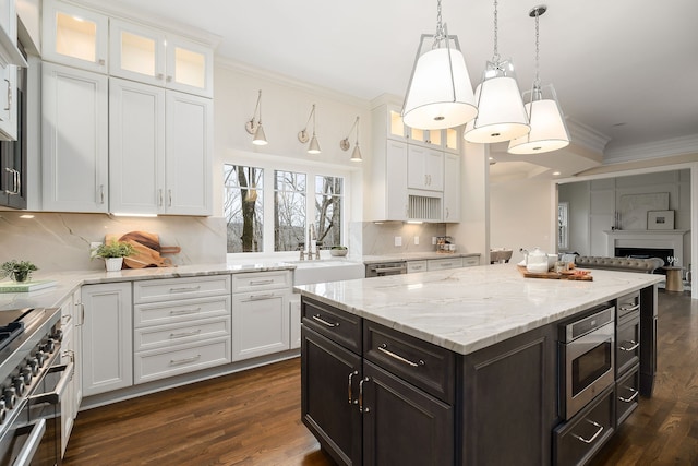 kitchen featuring dark hardwood / wood-style flooring, white cabinets, stainless steel appliances, and ornamental molding