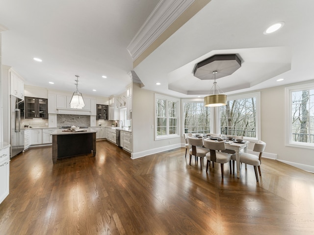 dining area featuring dark hardwood / wood-style floors and a raised ceiling