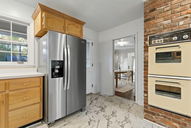 kitchen featuring white double oven and stainless steel refrigerator with ice dispenser