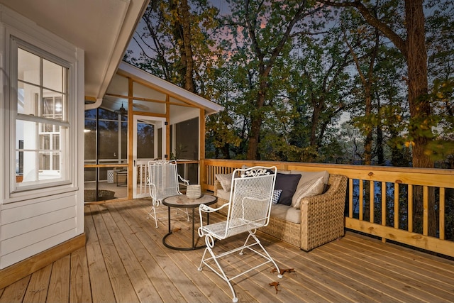 deck at dusk featuring a sunroom