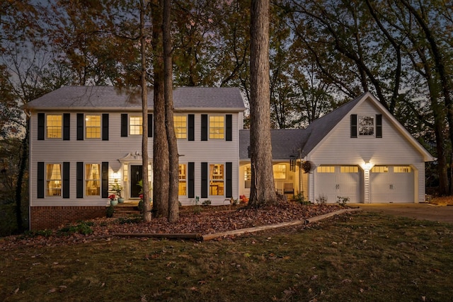 colonial-style house with a garage and a front lawn