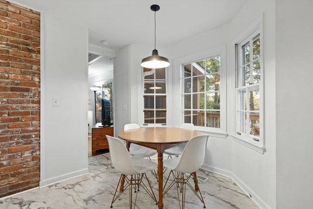 dining area featuring brick wall