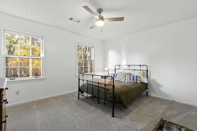 carpeted bedroom featuring multiple windows and ceiling fan