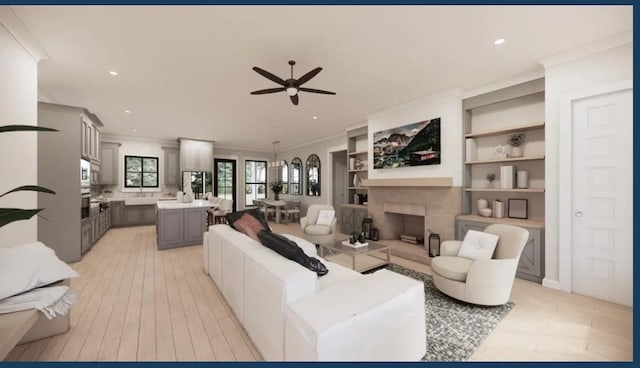 living room featuring built in shelves, ceiling fan, ornamental molding, and light wood-type flooring