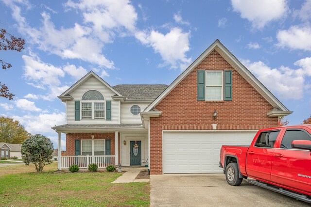 view of front property with a garage, covered porch, and a front yard