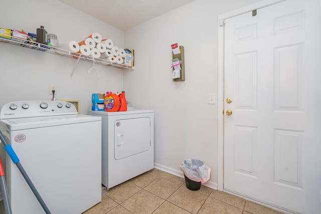 clothes washing area featuring washing machine and dryer and light tile patterned flooring