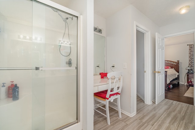 bathroom featuring a shower with door, wood-type flooring, and a textured ceiling