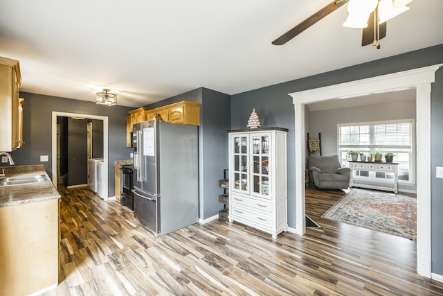 kitchen featuring stainless steel fridge, dark hardwood / wood-style flooring, sink, and washing machine and dryer