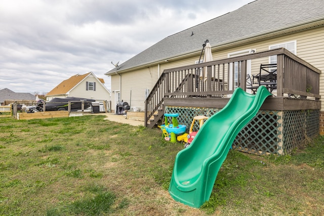 view of playground featuring a deck and a yard