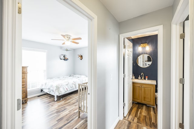 bedroom with dark hardwood / wood-style floors, ceiling fan, and ensuite bathroom