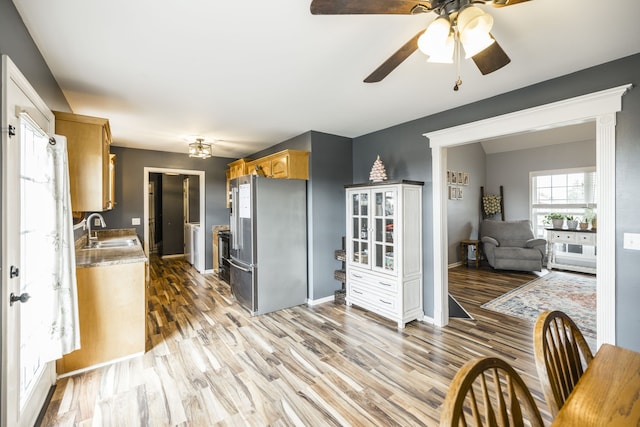 kitchen featuring stainless steel fridge, hardwood / wood-style flooring, ceiling fan, and sink