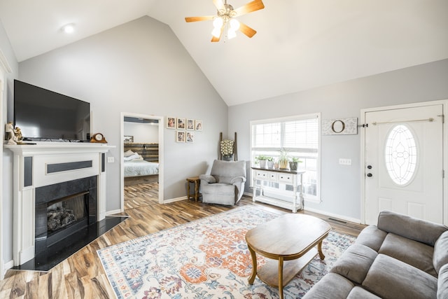 living room with wood-type flooring, high vaulted ceiling, and ceiling fan