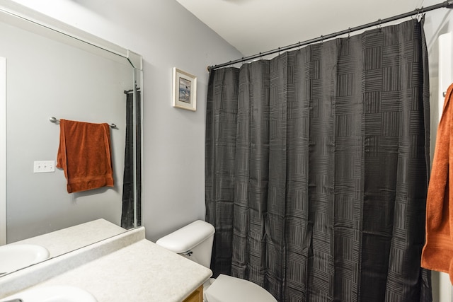 bathroom featuring vanity, curtained shower, and toilet