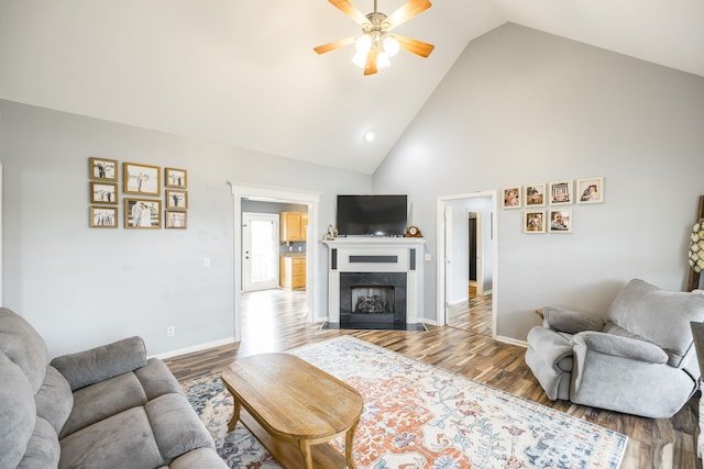 living room with hardwood / wood-style flooring, high vaulted ceiling, and ceiling fan