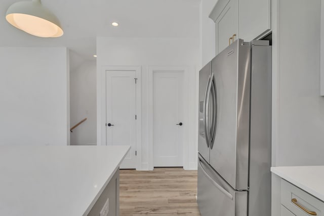 kitchen featuring stainless steel fridge and light hardwood / wood-style flooring