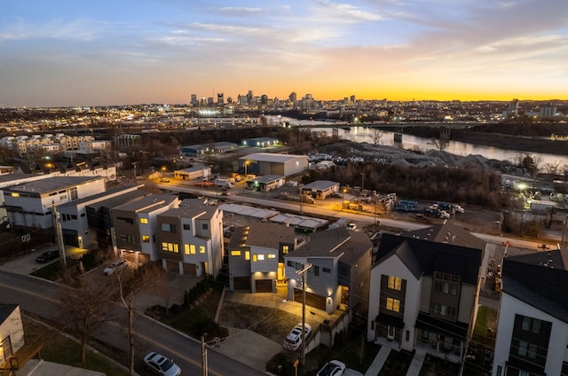 aerial view at dusk featuring a water view