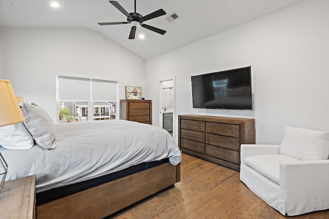 bedroom with ensuite bathroom, ceiling fan, wood-type flooring, and vaulted ceiling