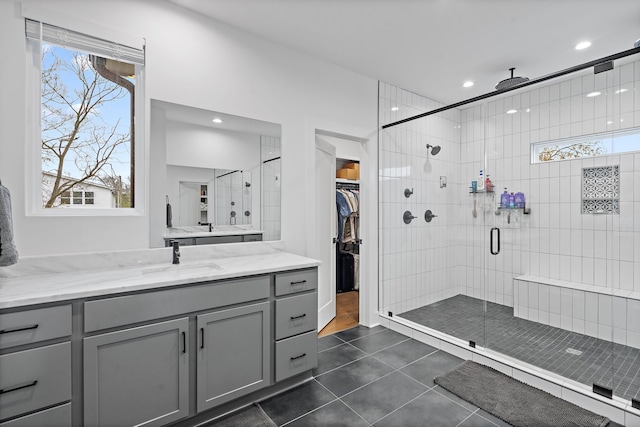 bathroom featuring walk in shower, vanity, tile patterned floors, and a wealth of natural light