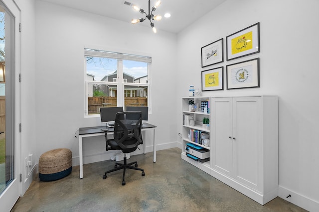 home office with a chandelier and concrete floors