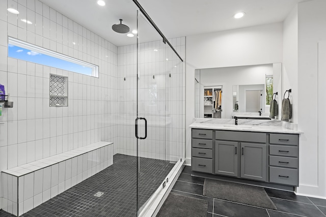 bathroom with tile patterned flooring, vanity, and a shower with door