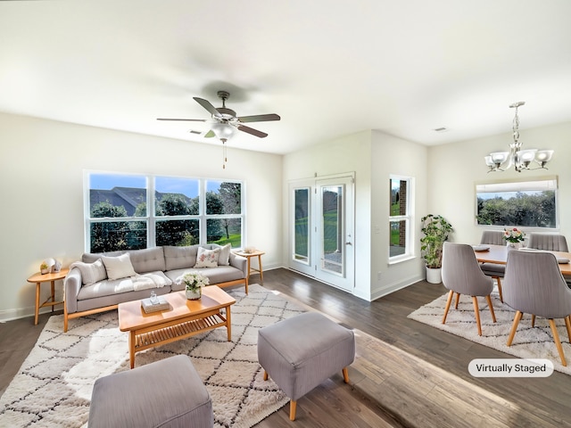 living room featuring ceiling fan with notable chandelier, dark hardwood / wood-style floors, and a wealth of natural light