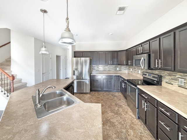 kitchen featuring pendant lighting, backsplash, stainless steel appliances, and sink