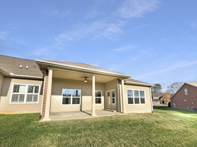 rear view of house featuring ceiling fan, a patio area, and a lawn