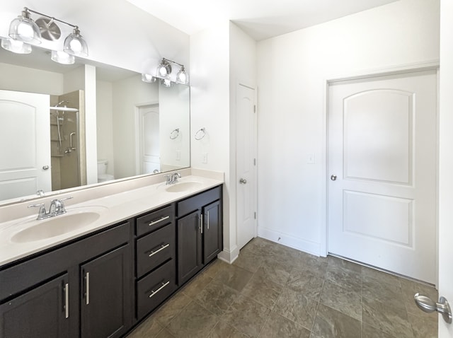 bathroom with vanity, a shower with shower door, and toilet