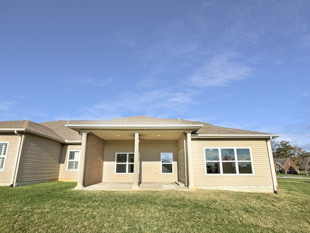 rear view of house featuring a lawn and a patio area