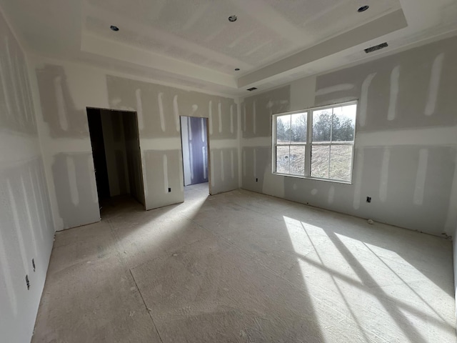 empty room featuring a raised ceiling and visible vents