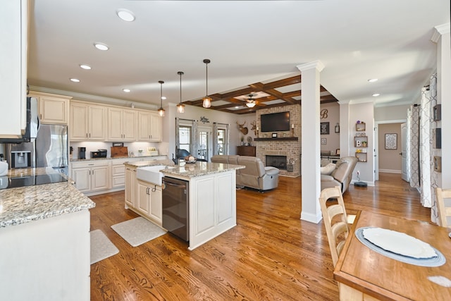 kitchen with sink, a center island, pendant lighting, appliances with stainless steel finishes, and light wood-type flooring