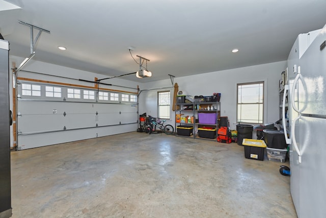 garage featuring white fridge and a garage door opener