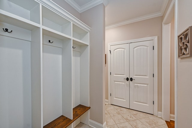 mudroom with ornamental molding and light tile patterned floors