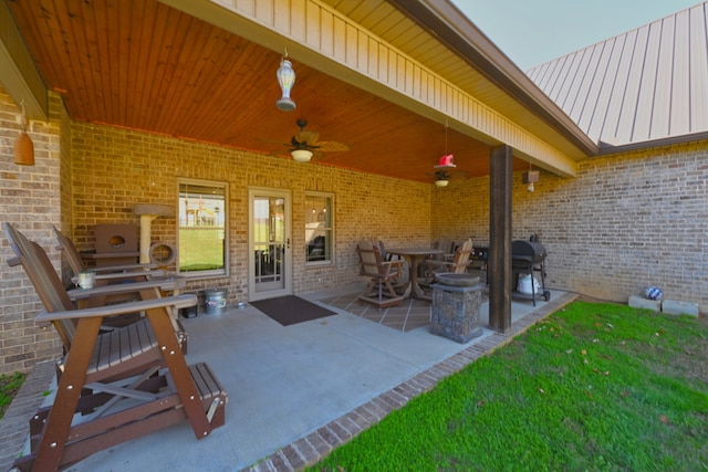 view of patio / terrace with ceiling fan and a fireplace