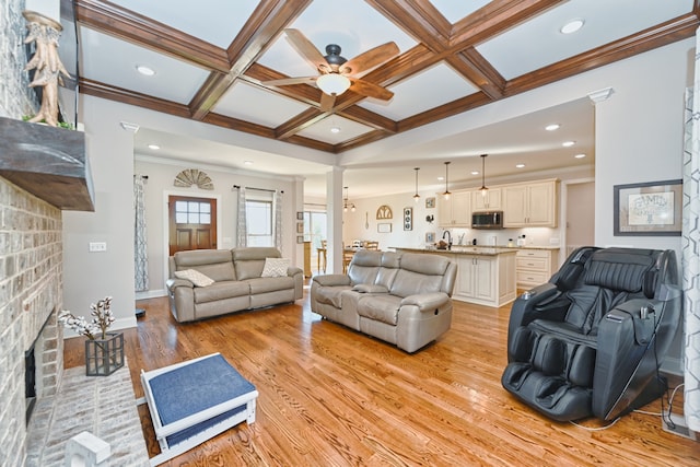 living room featuring a fireplace, beam ceiling, light hardwood / wood-style flooring, and coffered ceiling