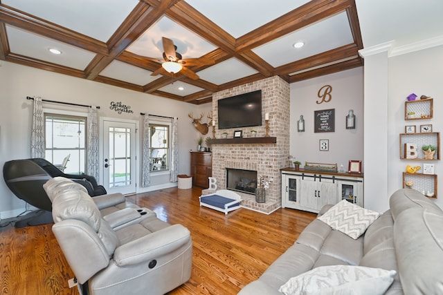 living room featuring hardwood / wood-style flooring, beam ceiling, coffered ceiling, and a brick fireplace