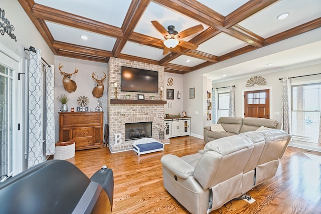 living room with light hardwood / wood-style flooring, beamed ceiling, and coffered ceiling