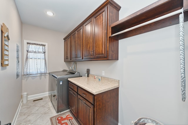 laundry room featuring cabinets and washing machine and clothes dryer