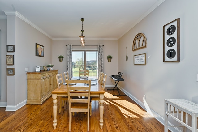 dining area featuring wood-type flooring and crown molding